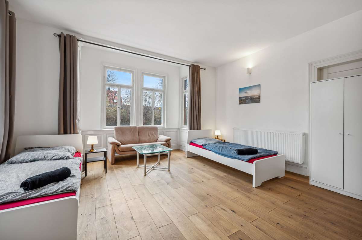 Zimmer mit zwei Einzelbetten und Sofa im Haus Silcherstraße 13