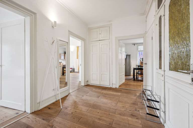 Hallway with panelled doors and oak floorboards at Silcherstraße 13