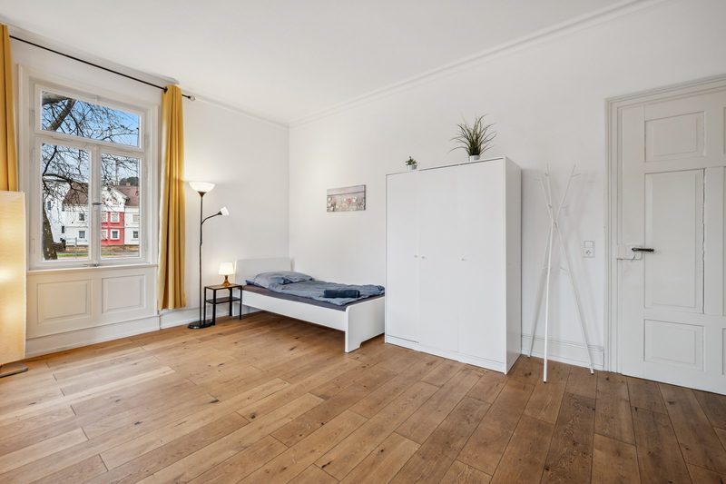 Schlafzimmer mit hohen Altbaufenstern